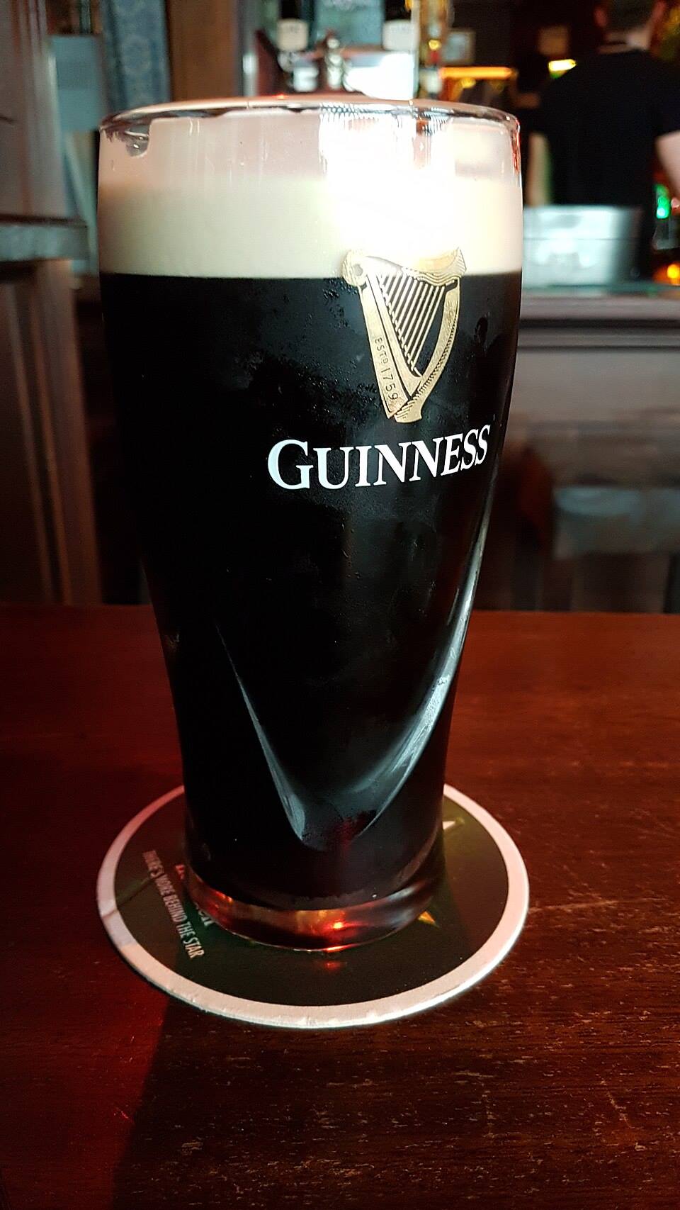 A freshly poured pint of Guinness on a pub bar