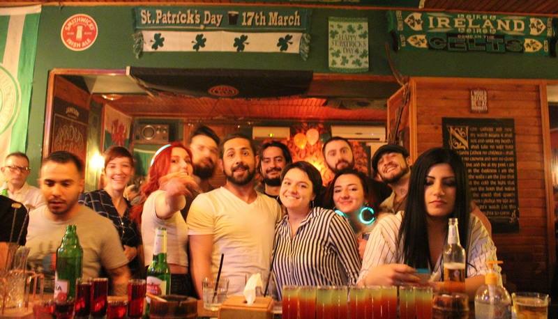 The Irish Fam posing together under St. Patrick's Day banners